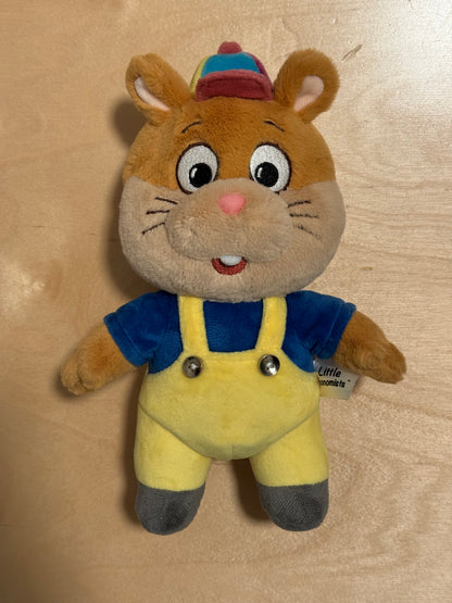 Plush toy resembling a hamster in a blue outfit on a beige background